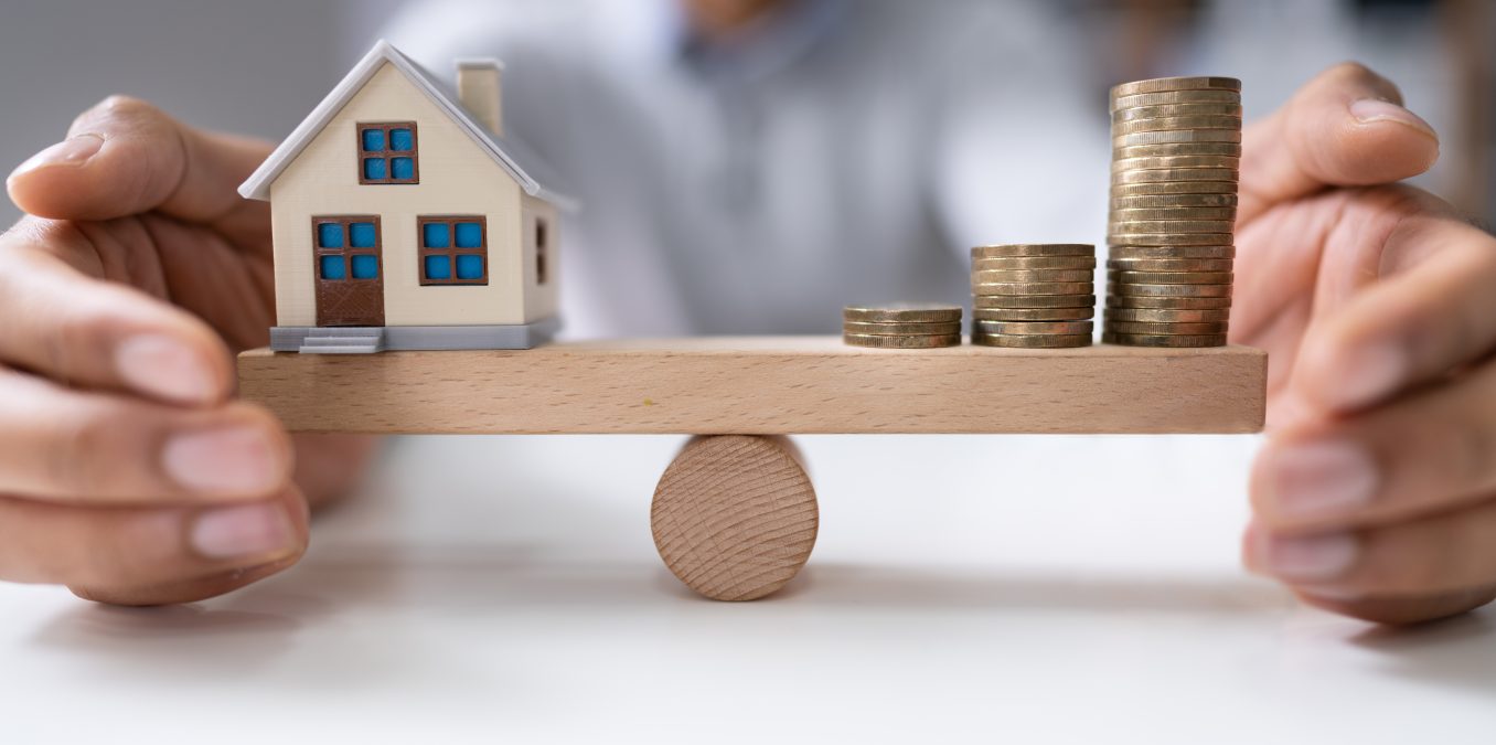 Businessperson's,Hand,Protecting,Balance,Between,House,Model,And,Increasing,Stacked