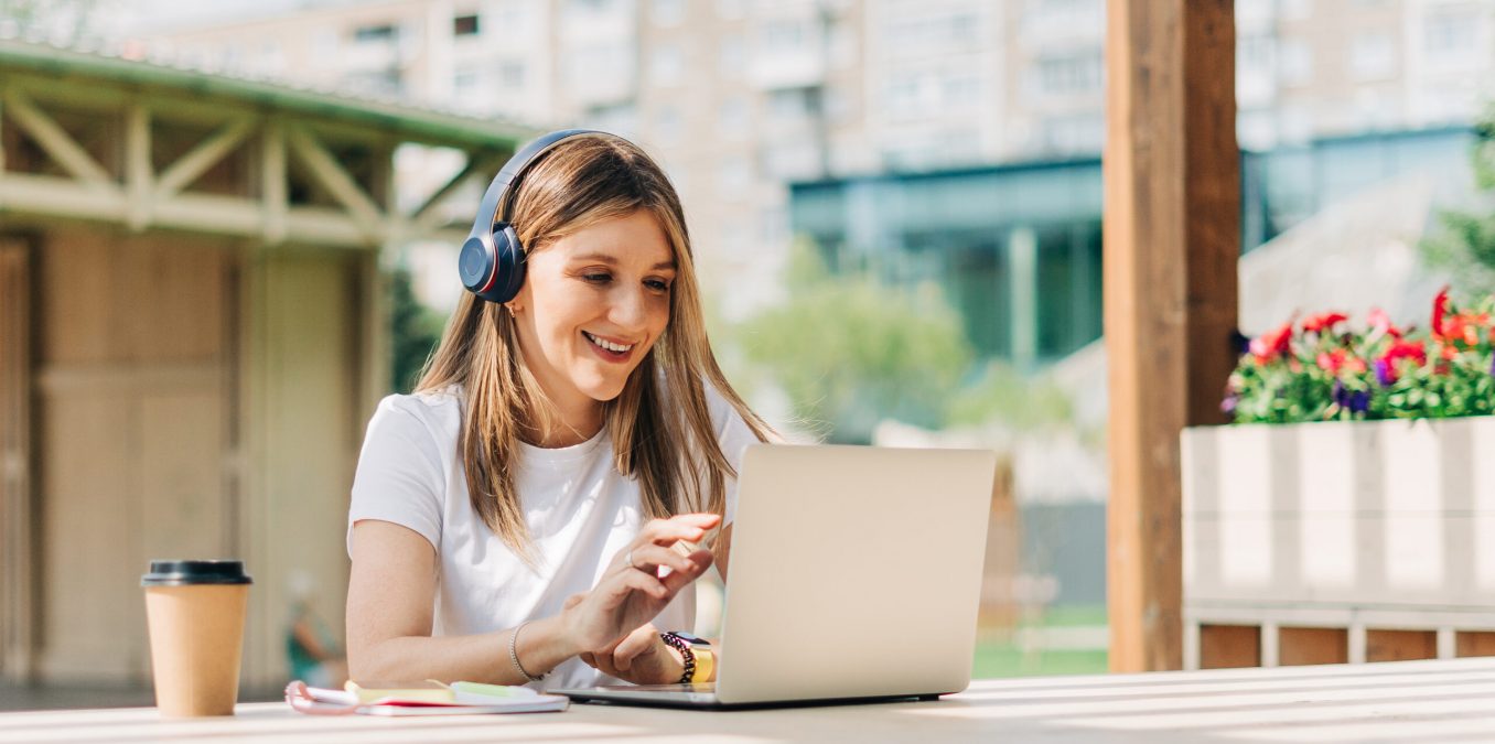 Young,Hipster,Woman,In,Headphones,Using,Laptop,,Having,A,Video