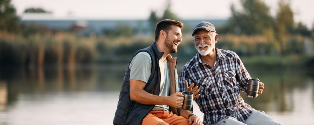 Happy,Senior,Fisherman,And,His,Adult,Son,Talking,While,Having