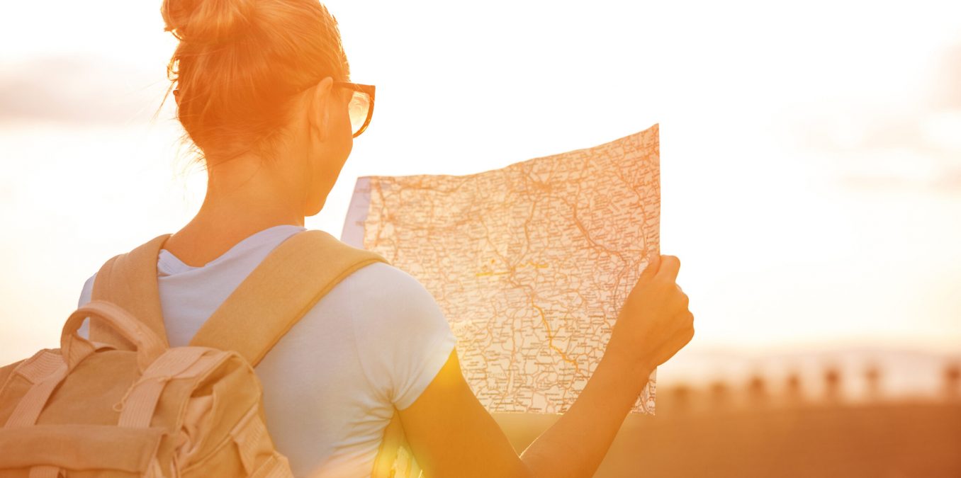 Back,Side,Of,Traveler,Girl,Searching,Right,Direction,On,Map,