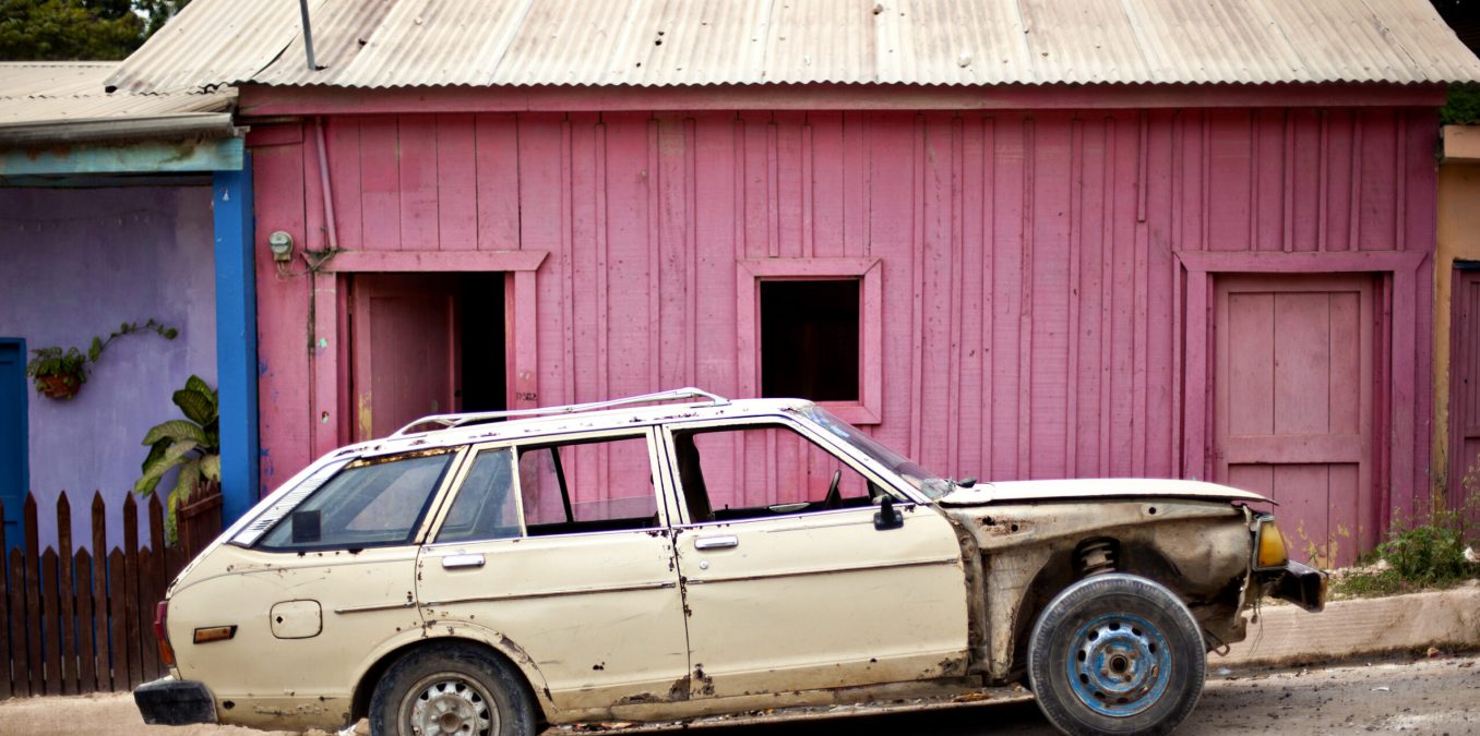 Old,Car,In,Front,Of,Pink,Building