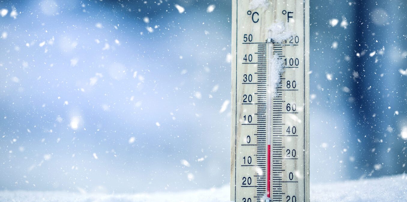 Thermometer on snow shows low temperatures in celsius or fahrenheit.