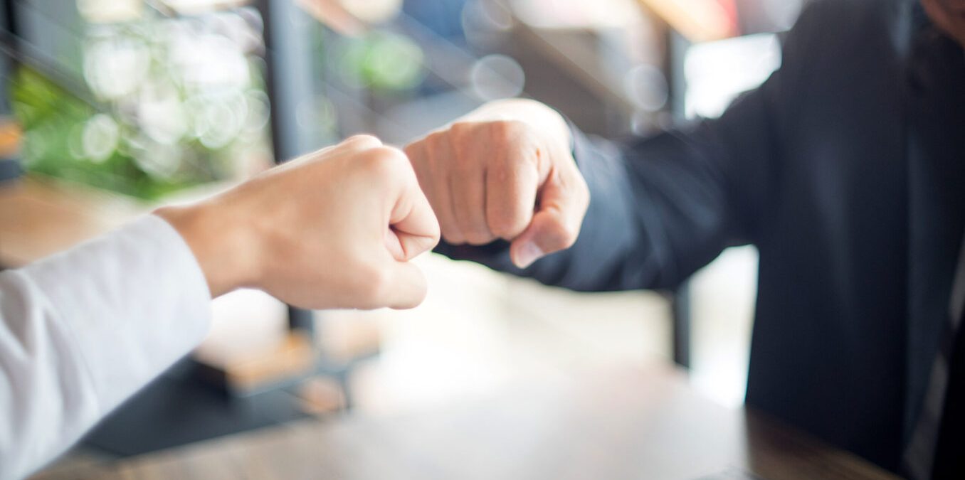 two business man use hand to fist bump for success teamwork corporate