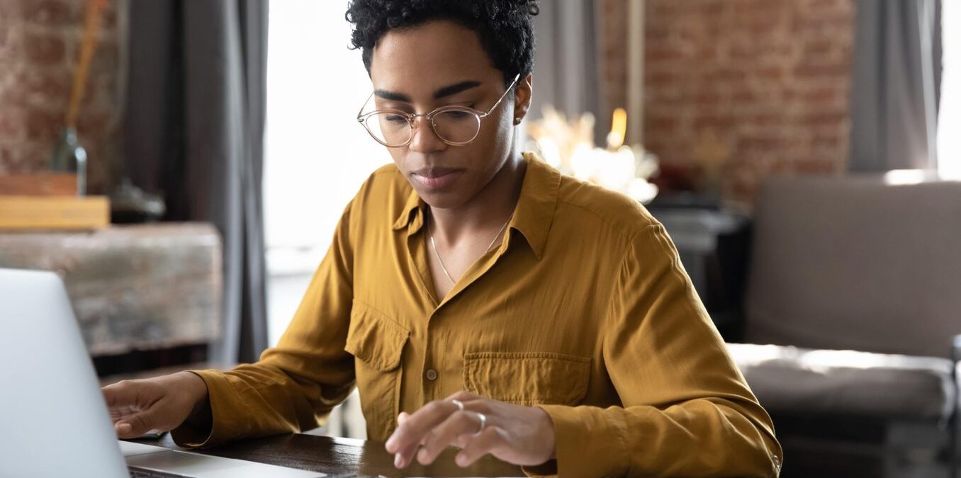 Woman doing calculations in front of laptop