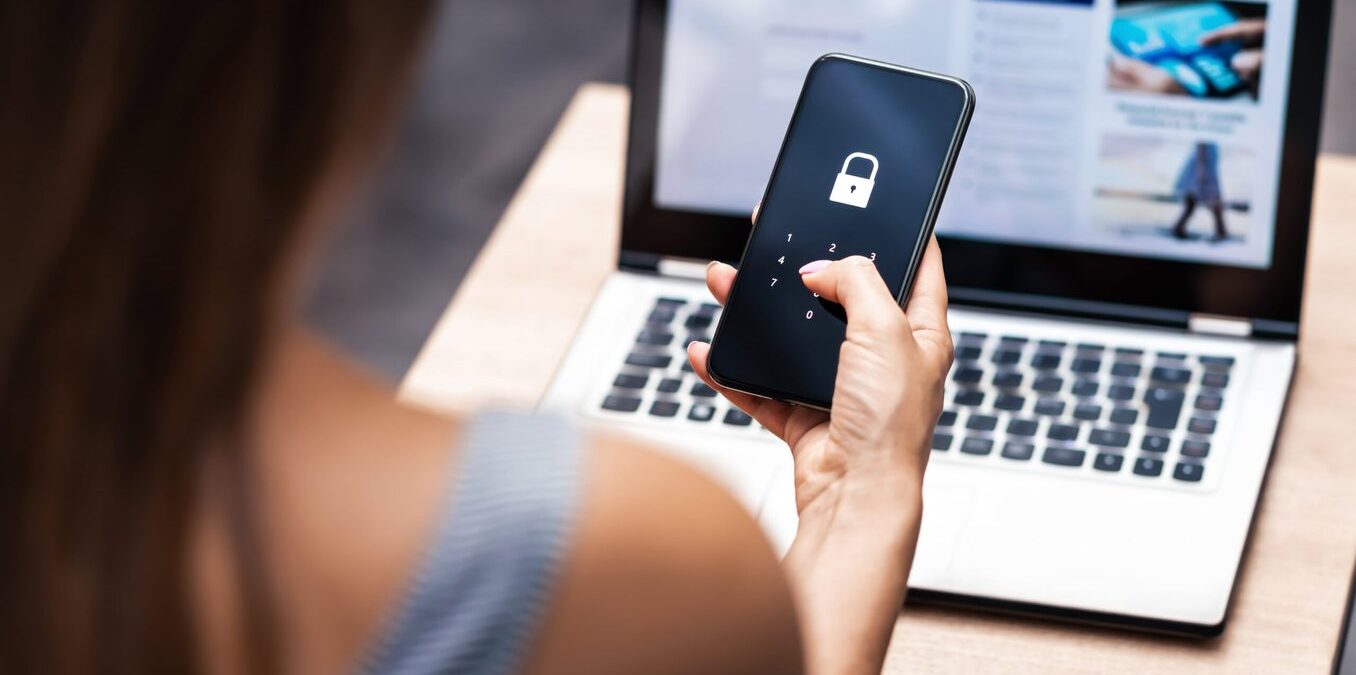 Close up of a woman holding phone and typing in security code