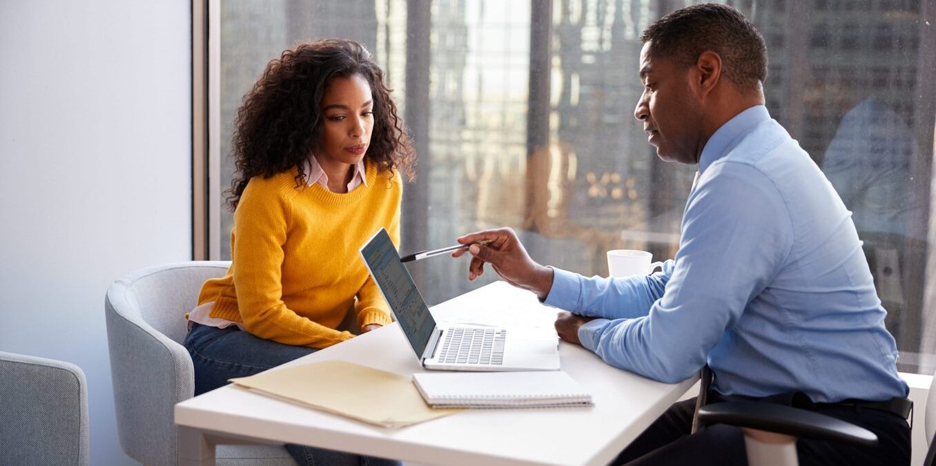 Woman Meeting With Male Financial Advisor Relationship Counsellor In Office