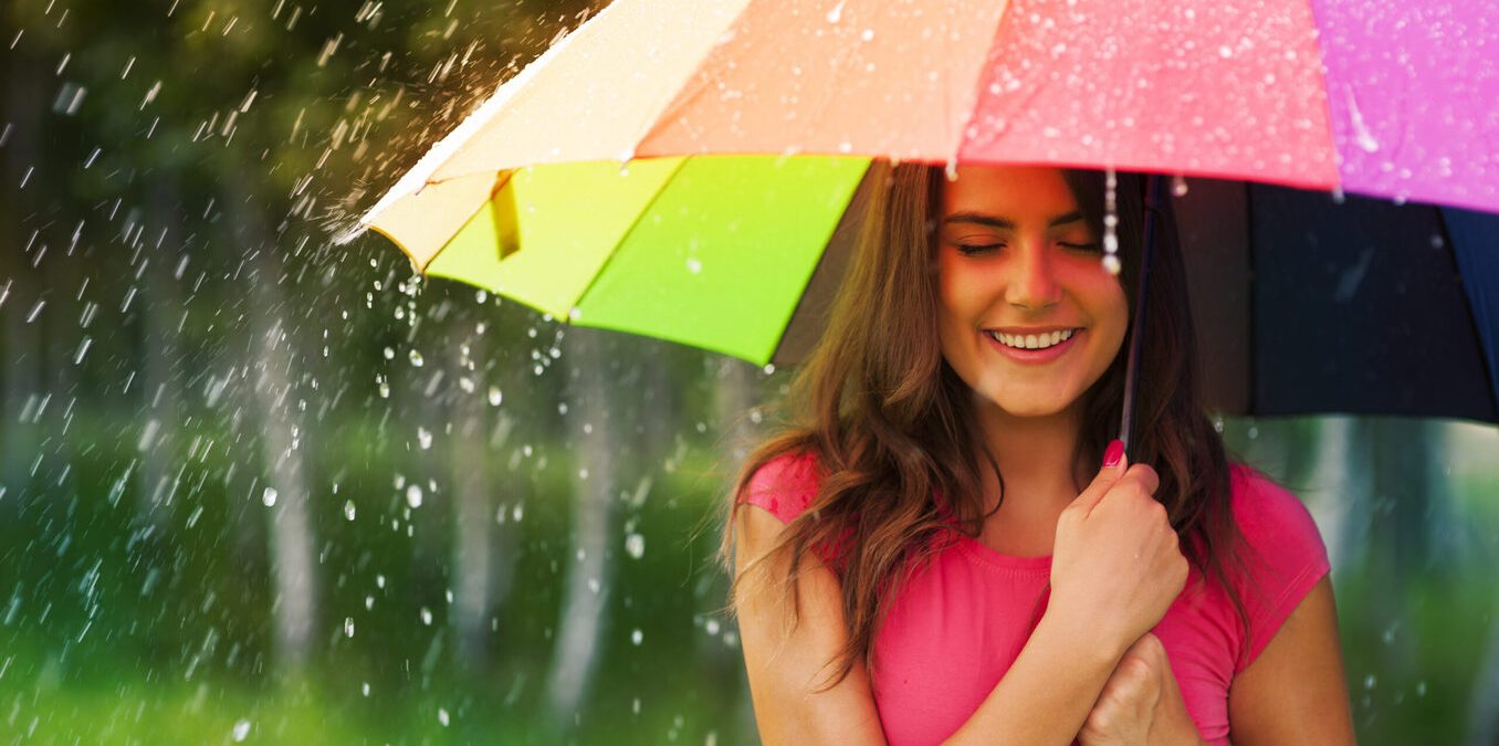 Woman under rainbow umbrella