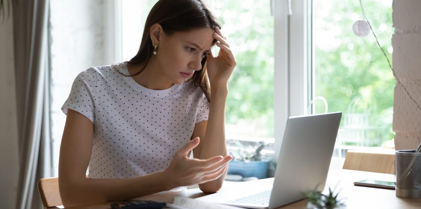 Woman using laptop looking confused