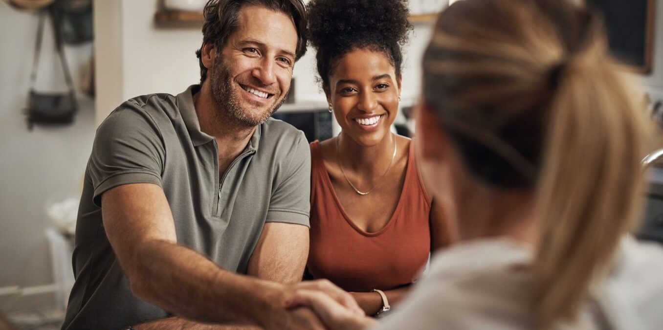 Young couple handshaking with advisor