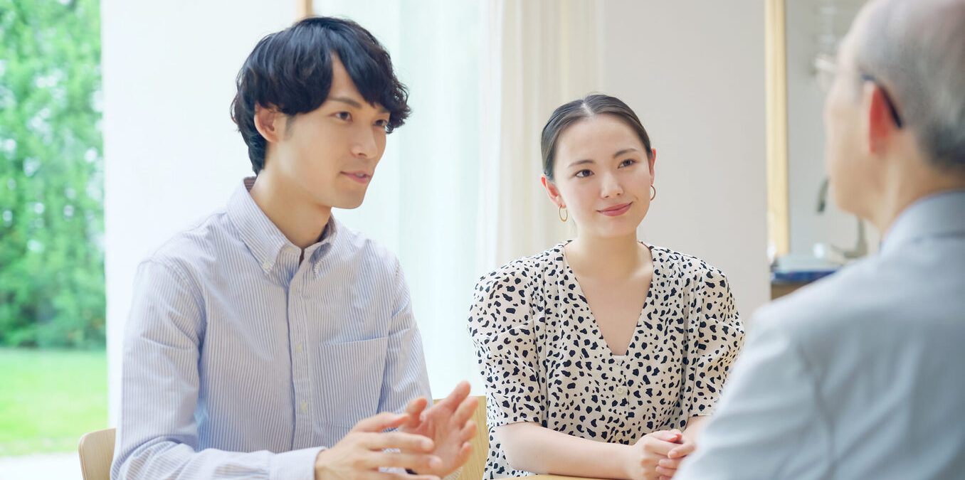Young Asian couple talking with a senior man