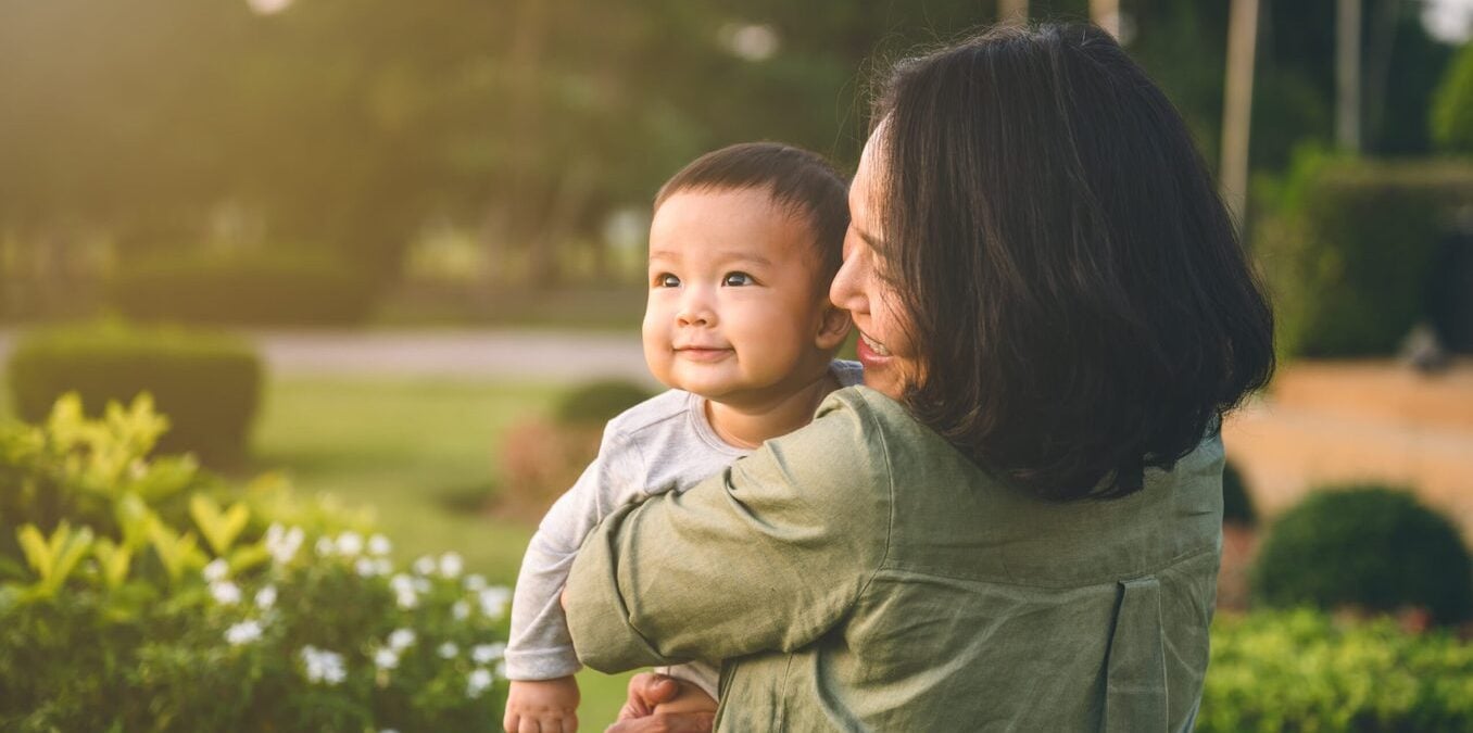 Young mother holding a baby in nature